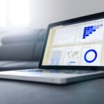 Sleek laptop showcasing data analytics and graphs on the screen in a bright room.