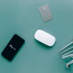 Flat lay of smartphone, cards, and shopping cart on green. Perfect for e-commerce and online shopping themes.