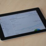 A digital tablet showing a web analytics dashboard with graphs and charts.